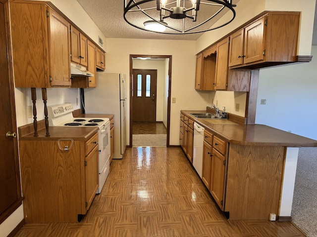 kitchen with sink, kitchen peninsula, a chandelier, a textured ceiling, and white appliances