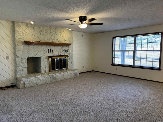 unfurnished living room featuring a fireplace, carpet, a textured ceiling, and ceiling fan