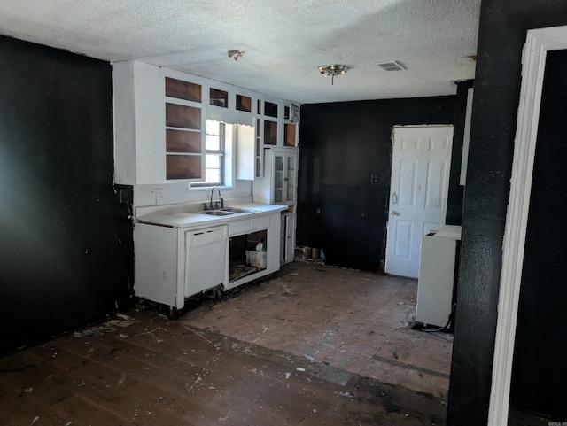 kitchen with white cabinetry, sink, and a textured ceiling