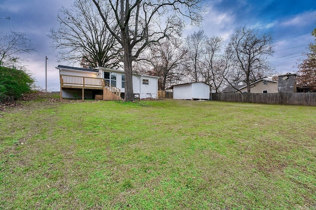 view of yard featuring a wooden deck and a shed