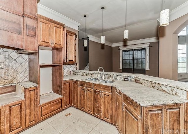 kitchen featuring sink, crown molding, pendant lighting, decorative backsplash, and light tile patterned flooring