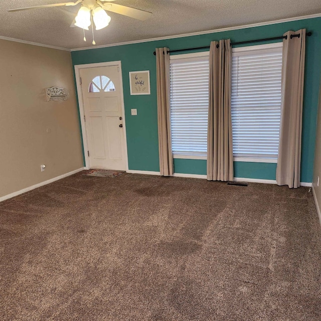 entryway featuring carpet, ceiling fan, ornamental molding, and a textured ceiling