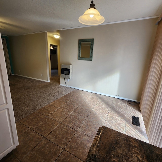 spare room with heating unit, a textured ceiling, and dark colored carpet