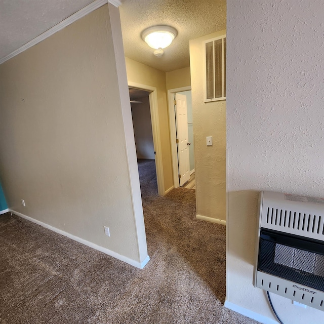 hall with carpet flooring, a textured ceiling, heating unit, and ornamental molding