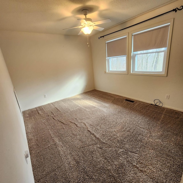 unfurnished room featuring carpet flooring, ceiling fan, and a textured ceiling