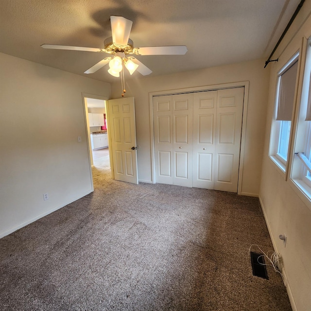 unfurnished bedroom with carpet flooring, a closet, and ceiling fan