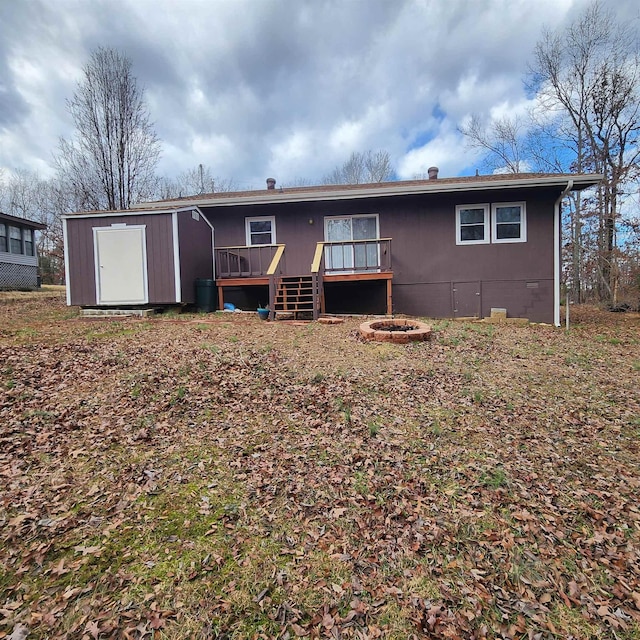 back of property featuring a deck and a storage shed