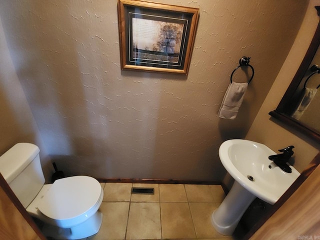 bathroom featuring toilet, tile patterned floors, and sink