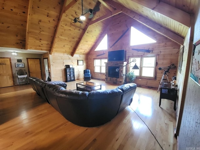 living room featuring wooden ceiling, beamed ceiling, wood walls, light hardwood / wood-style floors, and a fireplace