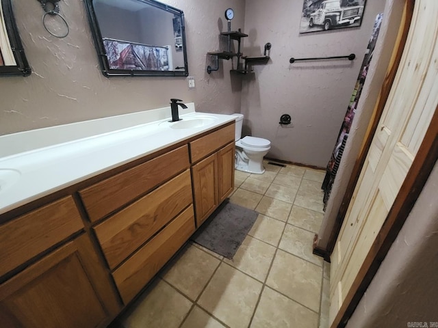 bathroom featuring tile patterned flooring, vanity, and toilet