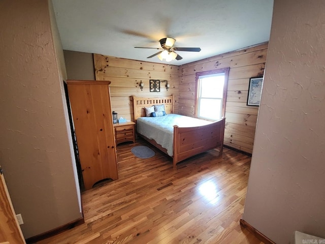 unfurnished bedroom featuring wood-type flooring, ceiling fan, and wood walls