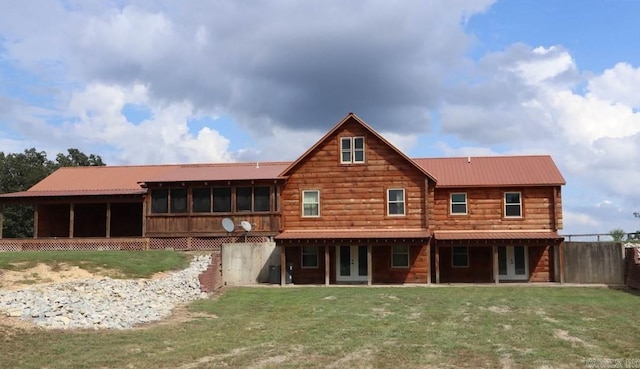 rear view of property with french doors, a yard, and a sunroom