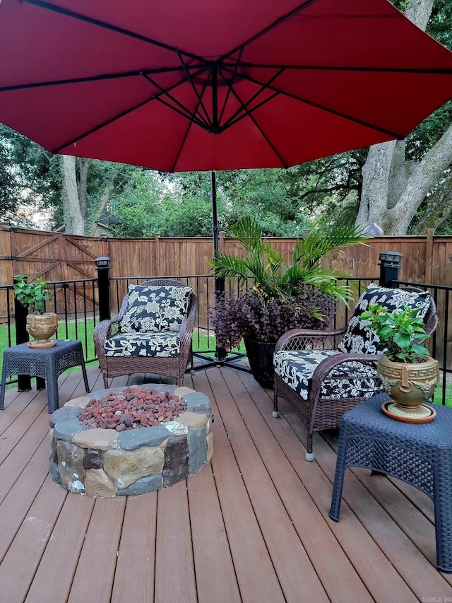 wooden deck featuring an outdoor living space with a fire pit