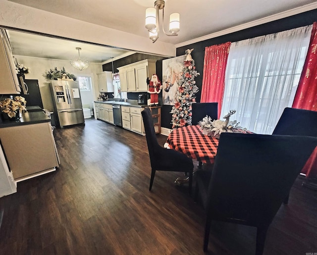 dining area featuring a chandelier, dark wood-type flooring, and a healthy amount of sunlight