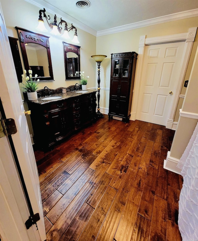 bathroom with crown molding, sink, and wood-type flooring