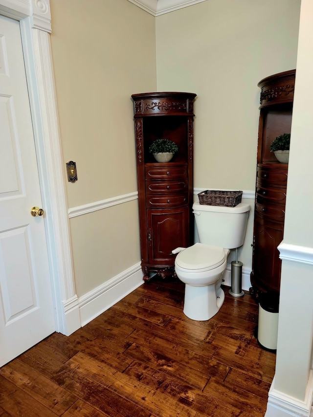 bathroom with crown molding, toilet, and hardwood / wood-style flooring