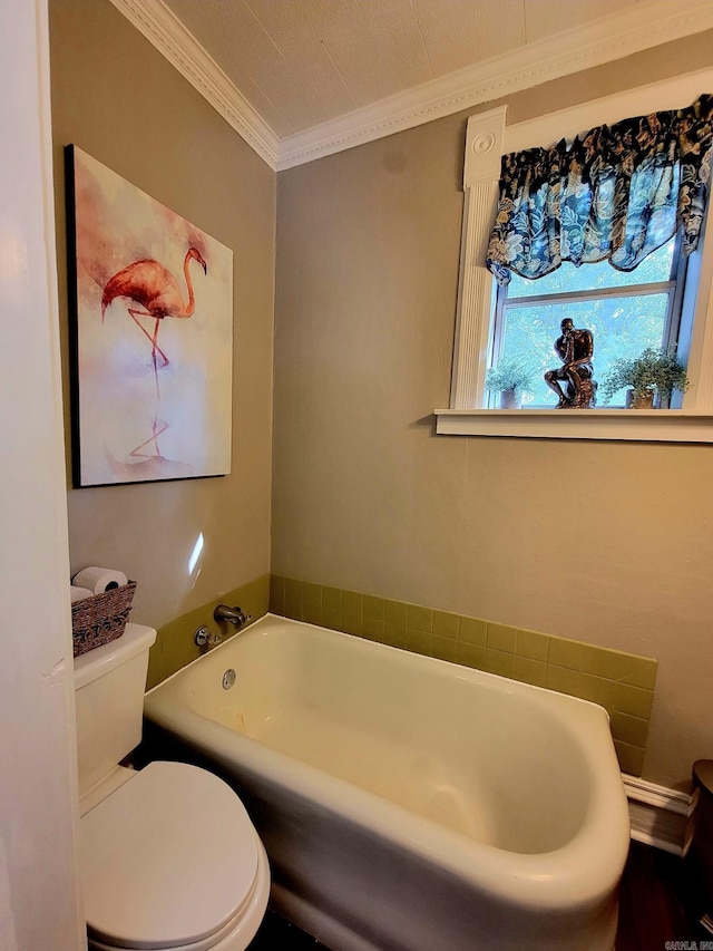 bathroom featuring a washtub, toilet, and crown molding