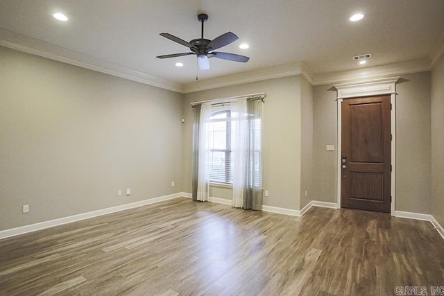 spare room featuring hardwood / wood-style floors, ceiling fan, and crown molding