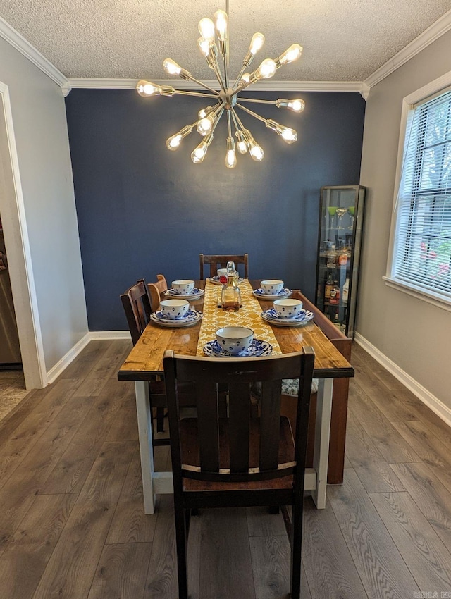 dining area featuring a chandelier, a textured ceiling, dark hardwood / wood-style floors, and ornamental molding