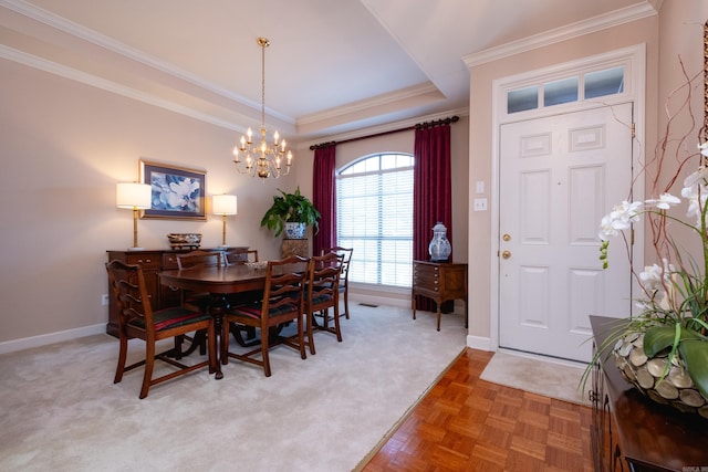 dining room with carpet, ornamental molding, and a notable chandelier