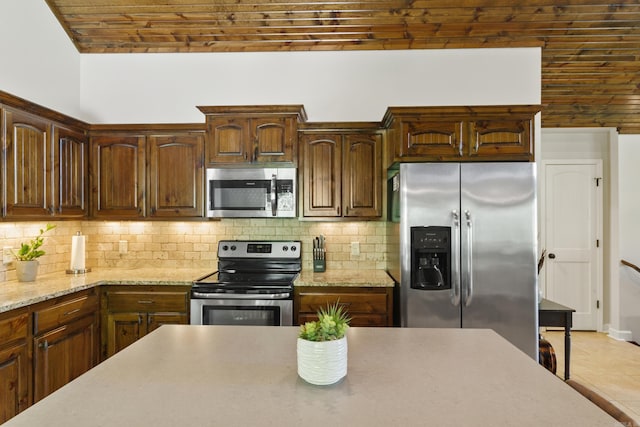 kitchen featuring brick ceiling, decorative backsplash, and appliances with stainless steel finishes