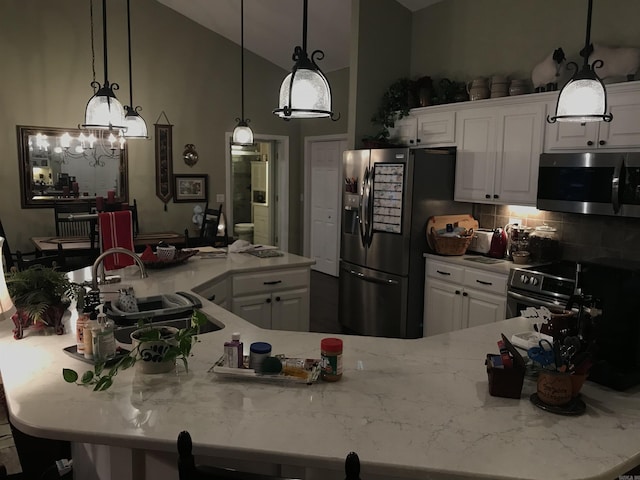 kitchen featuring backsplash, white cabinets, sink, and appliances with stainless steel finishes