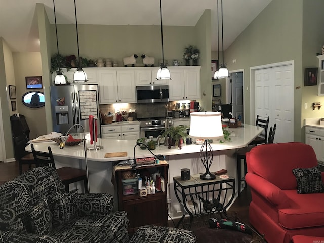 kitchen with backsplash, stainless steel appliances, a large island with sink, pendant lighting, and lofted ceiling