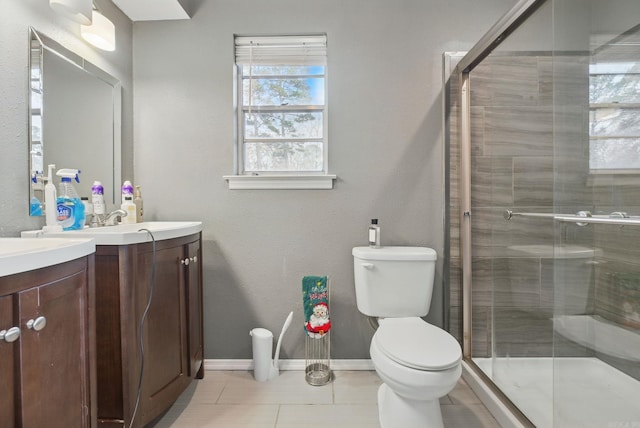 bathroom featuring tile patterned flooring, vanity, toilet, and a shower with shower door