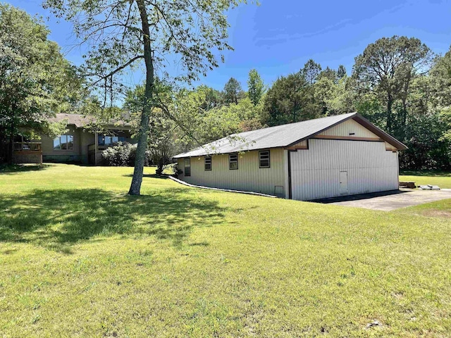 view of side of home featuring an outbuilding and a lawn