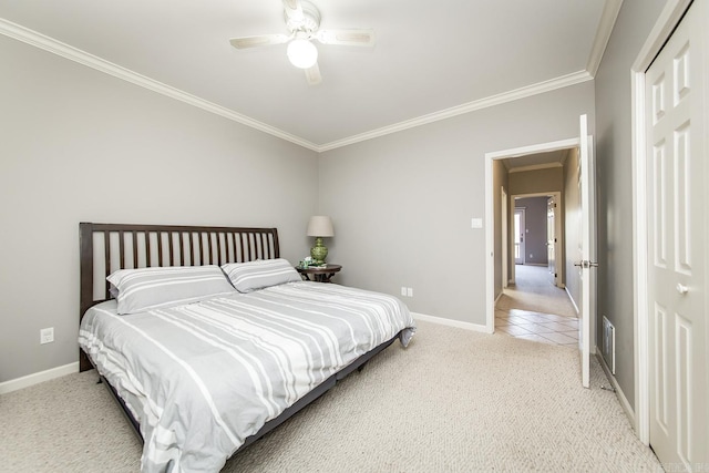 bedroom featuring crown molding, ceiling fan, a closet, and light colored carpet