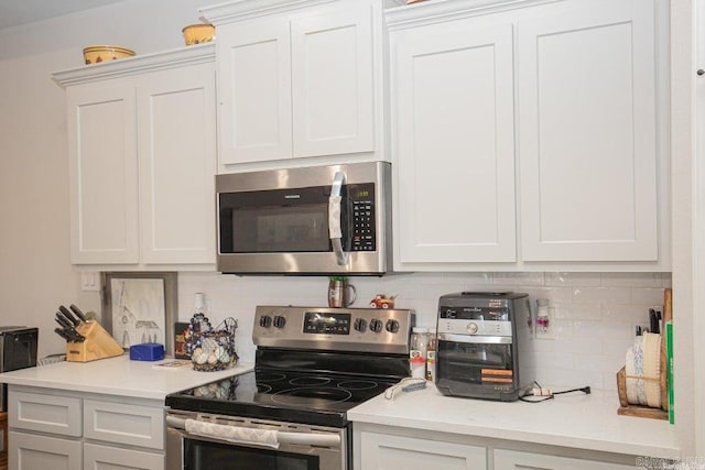 kitchen featuring appliances with stainless steel finishes, tasteful backsplash, and white cabinetry