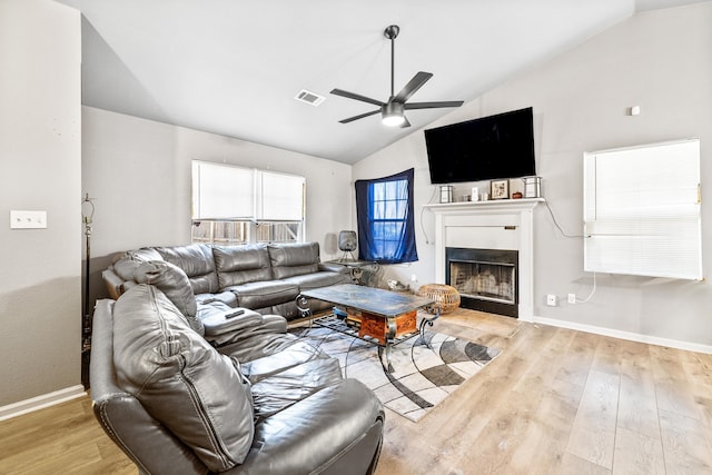 living room with ceiling fan, lofted ceiling, and light wood-type flooring