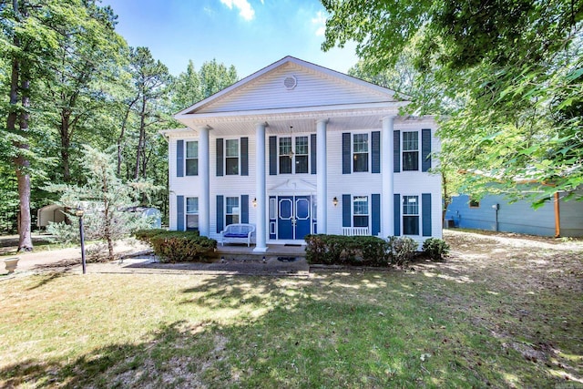 greek revival inspired property with a porch and a front lawn