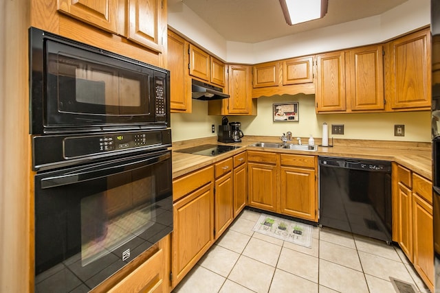 kitchen with black appliances, light tile patterned floors, and sink