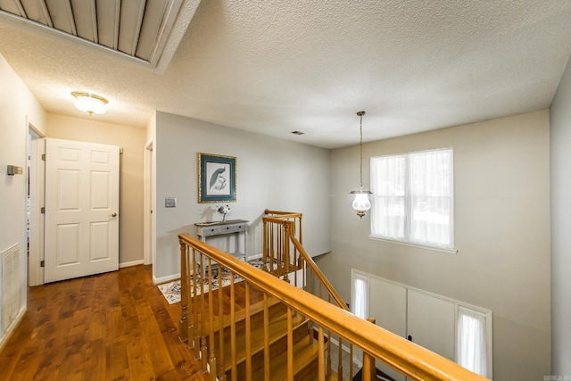 corridor featuring a textured ceiling and dark hardwood / wood-style floors