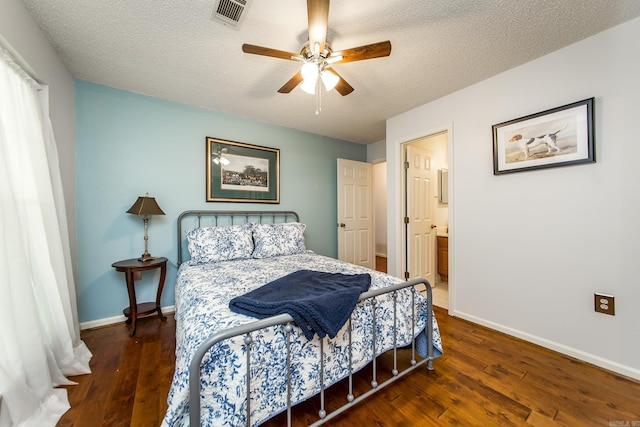 bedroom with a textured ceiling, connected bathroom, dark hardwood / wood-style floors, and ceiling fan