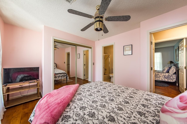 bedroom with a textured ceiling, a closet, ceiling fan, and dark wood-type flooring