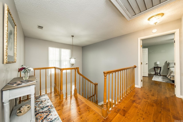 hall featuring a textured ceiling and dark hardwood / wood-style floors