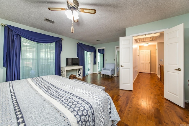 bedroom with a textured ceiling, dark hardwood / wood-style floors, and ceiling fan