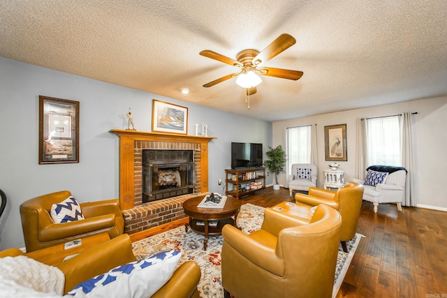 living room featuring a textured ceiling, ceiling fan, dark hardwood / wood-style flooring, and a fireplace