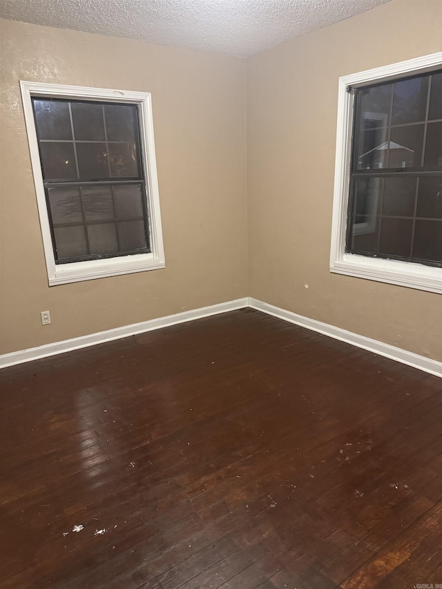 spare room featuring hardwood / wood-style flooring and a textured ceiling