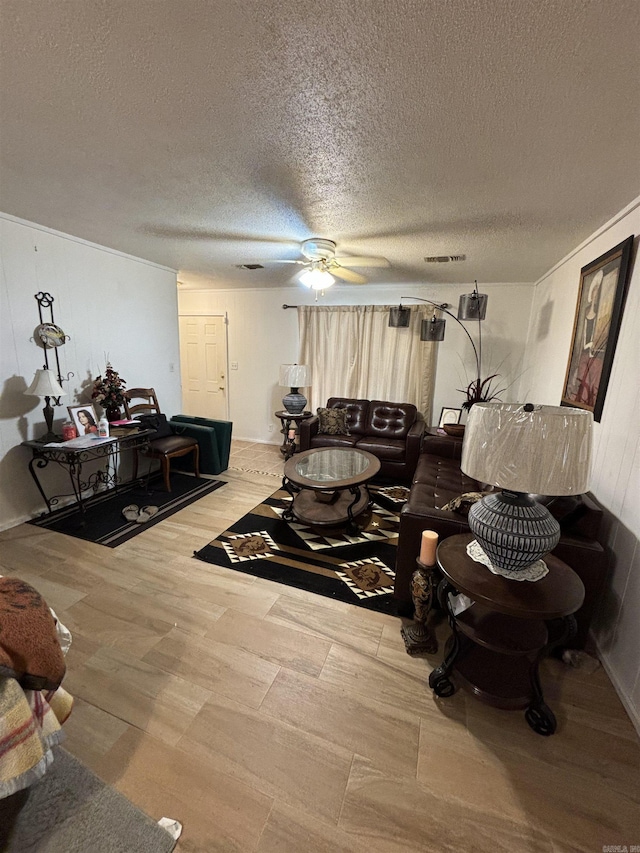 living room featuring ceiling fan and a textured ceiling