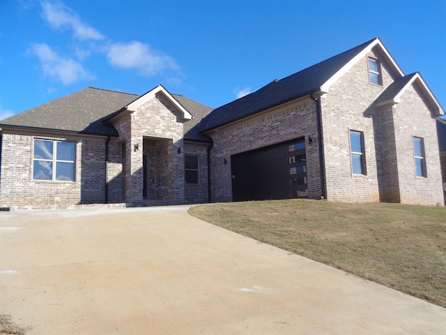 french provincial home with a garage and a front lawn