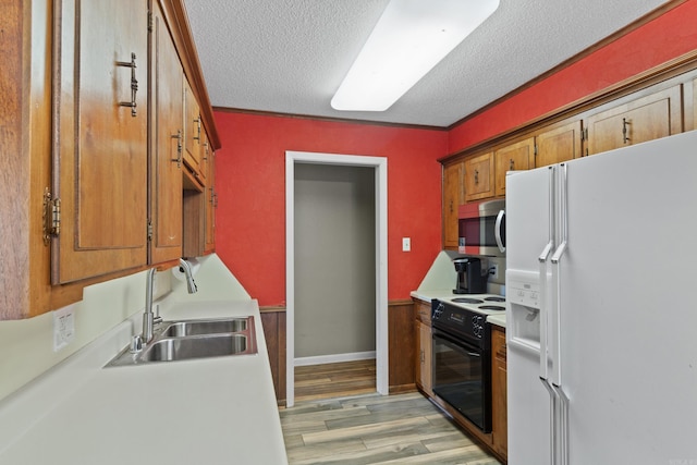 kitchen with white fridge with ice dispenser, black electric range oven, ornamental molding, and sink