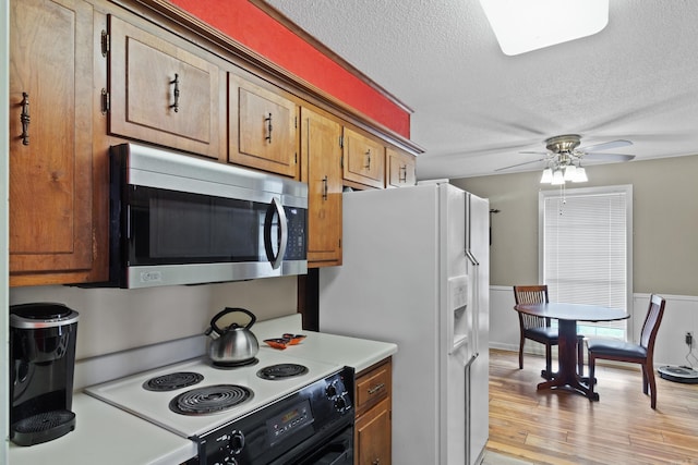 kitchen featuring a textured ceiling, ceiling fan, electric stove, light hardwood / wood-style floors, and white fridge with ice dispenser