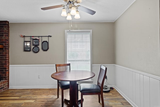 dining room with wood-type flooring, a textured ceiling, and ceiling fan