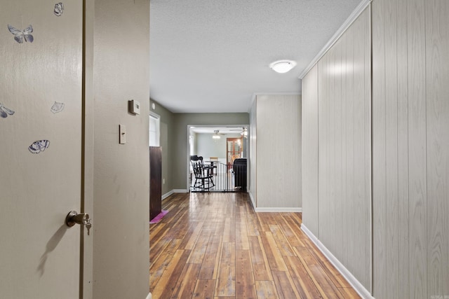 hall with hardwood / wood-style flooring and a textured ceiling