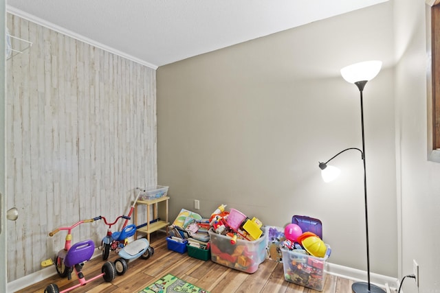 playroom with wood walls and hardwood / wood-style flooring