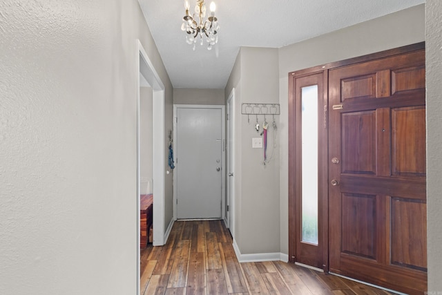 entryway with hardwood / wood-style flooring, a textured ceiling, and an inviting chandelier