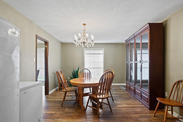 dining room featuring a textured ceiling, an inviting chandelier, and dark wood-type flooring